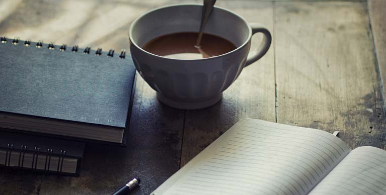 Cup with notebook and pen